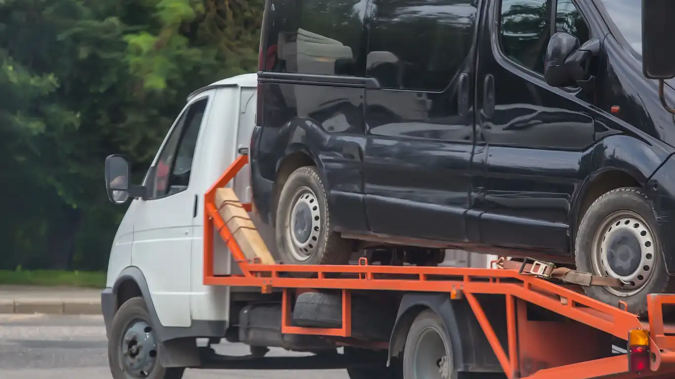 レッカー車に載せられている黒の車