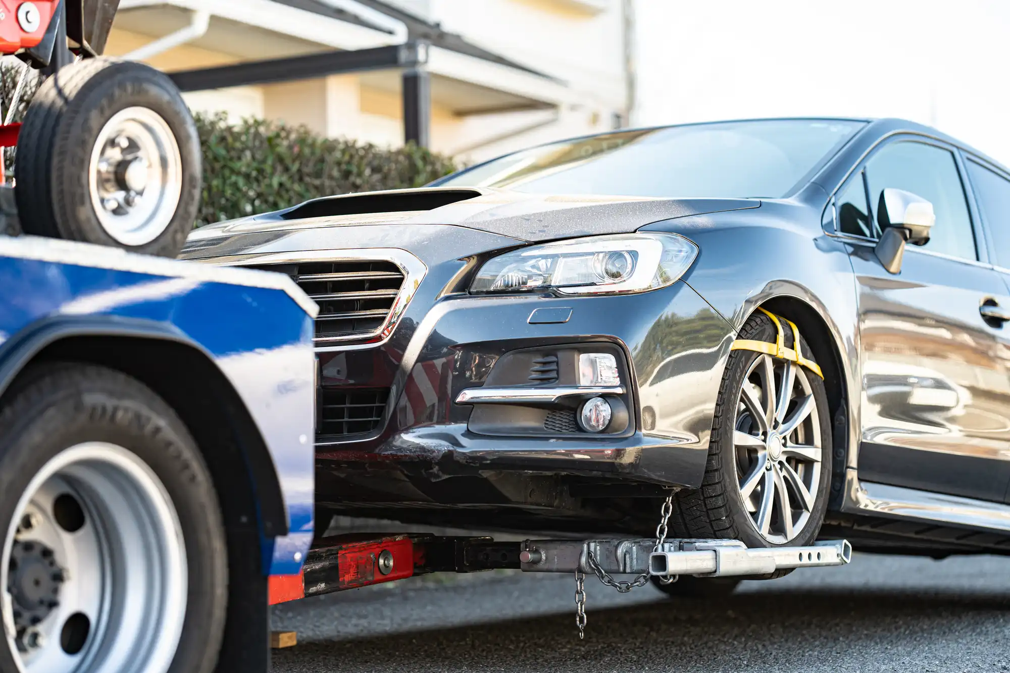 レッカー車に前輪を載せられた黒い車