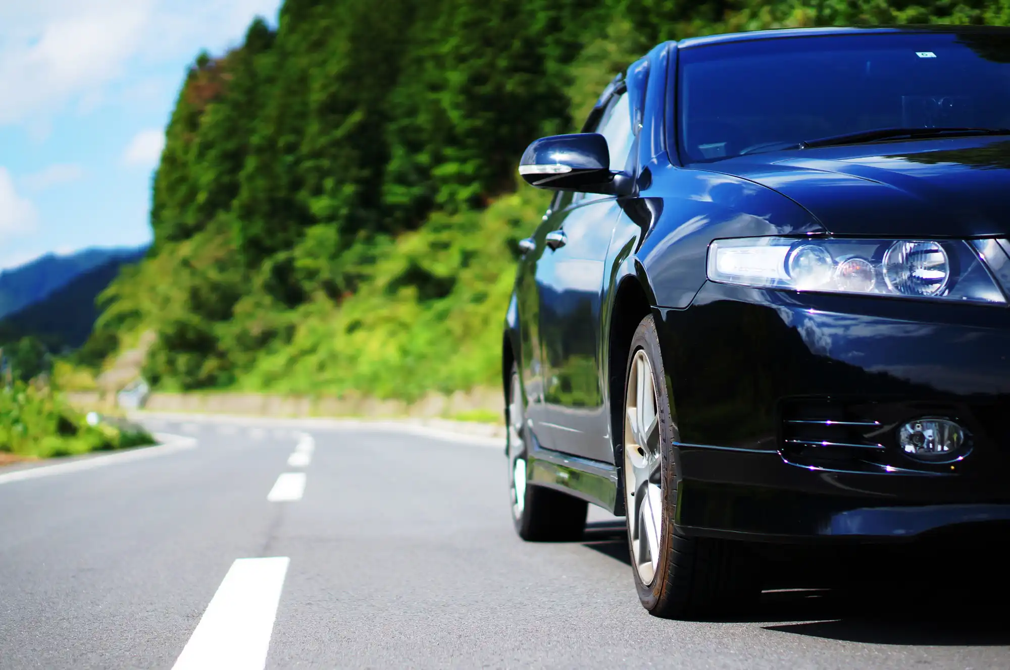 山道を走っている黒の自動車