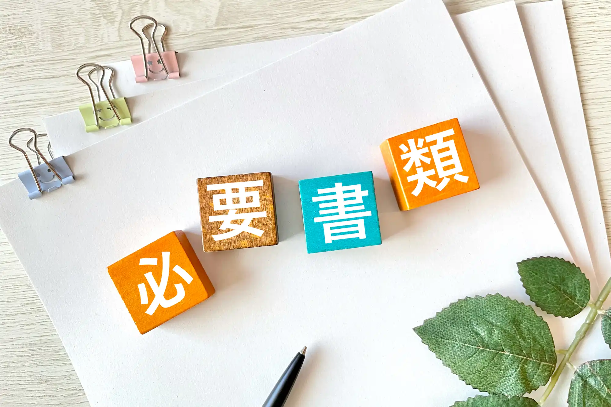 必要書類と書かれた積み木を紙の上に置いている