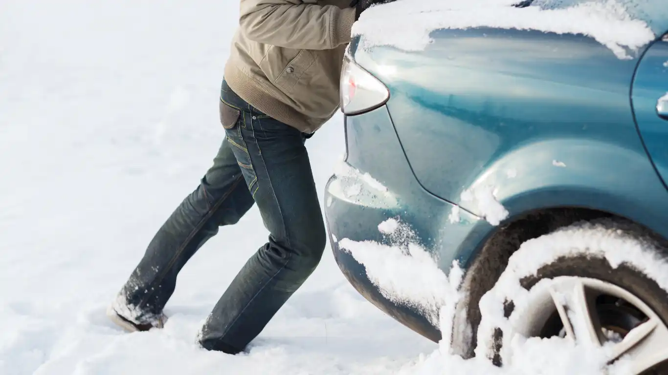 雪道で止まった車を押している