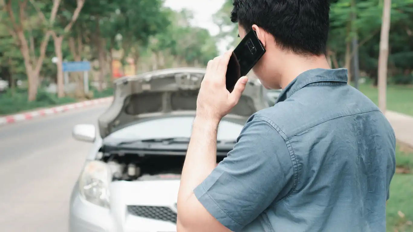 道端に停車し、ボンネットを開けて電話する男性