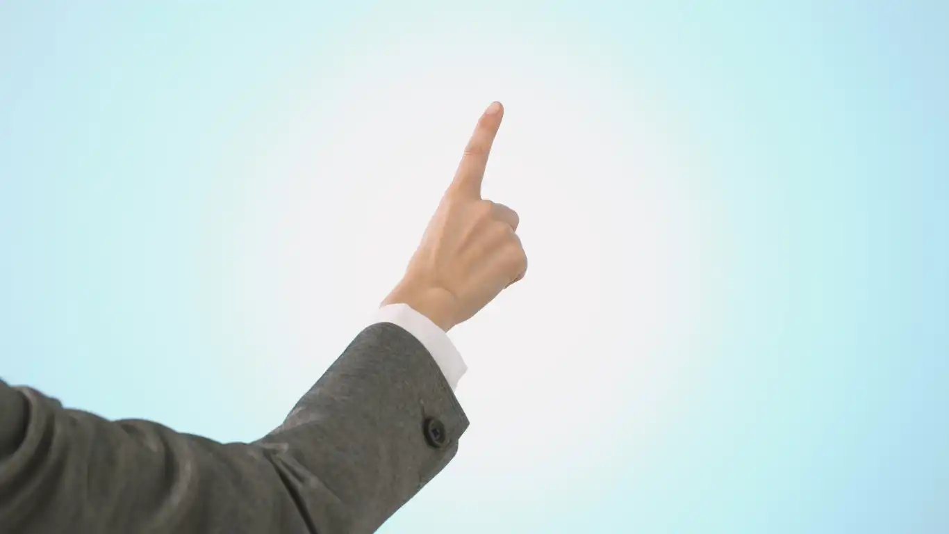 指差しポーズをしている