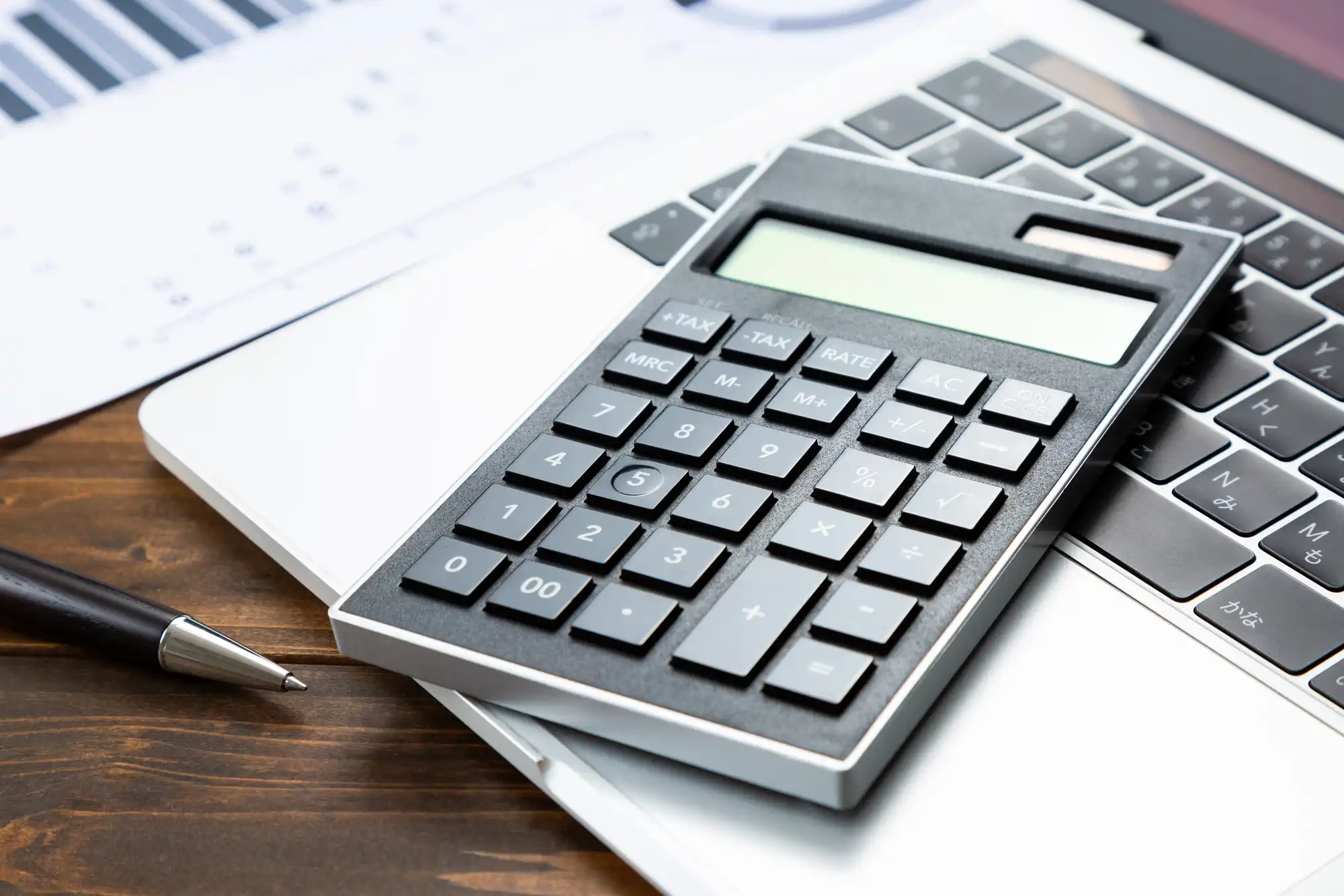 ノートPCの上に置かれた電卓