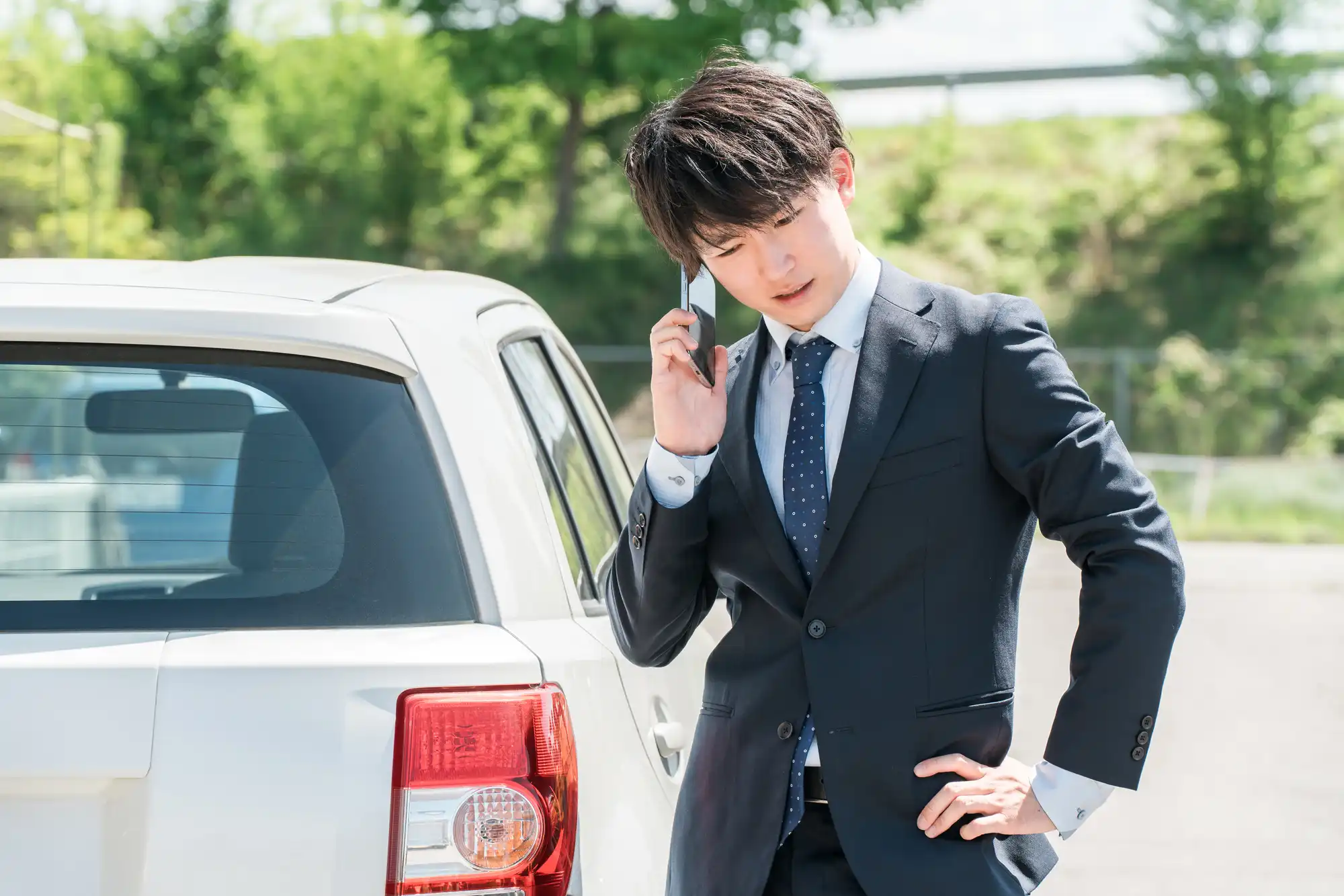 車の異常で困って電話する男性