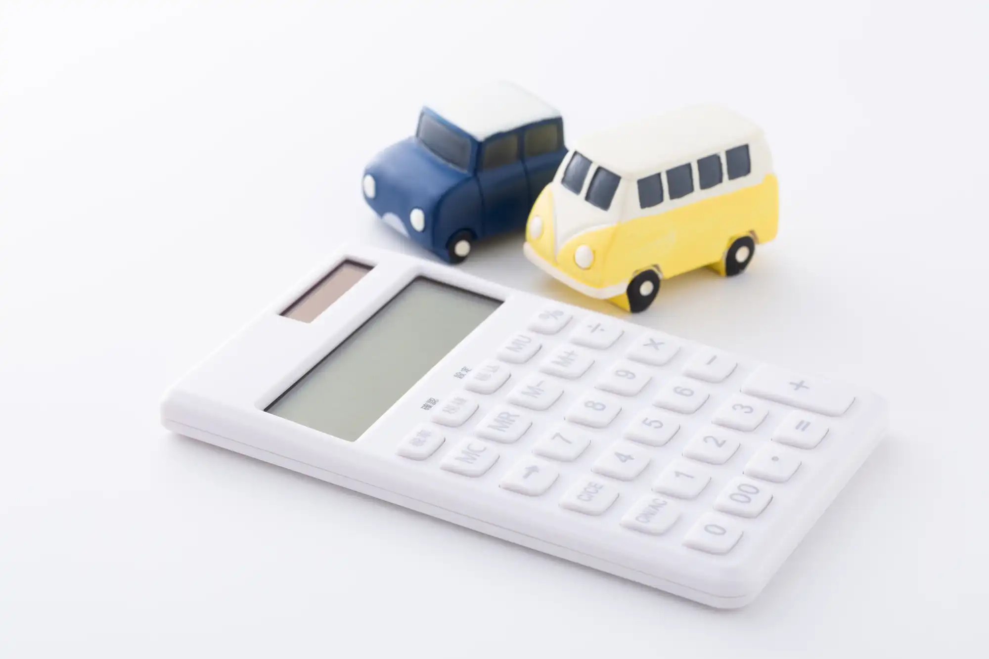 青と黄色のミニカーの横に電卓が置いてある