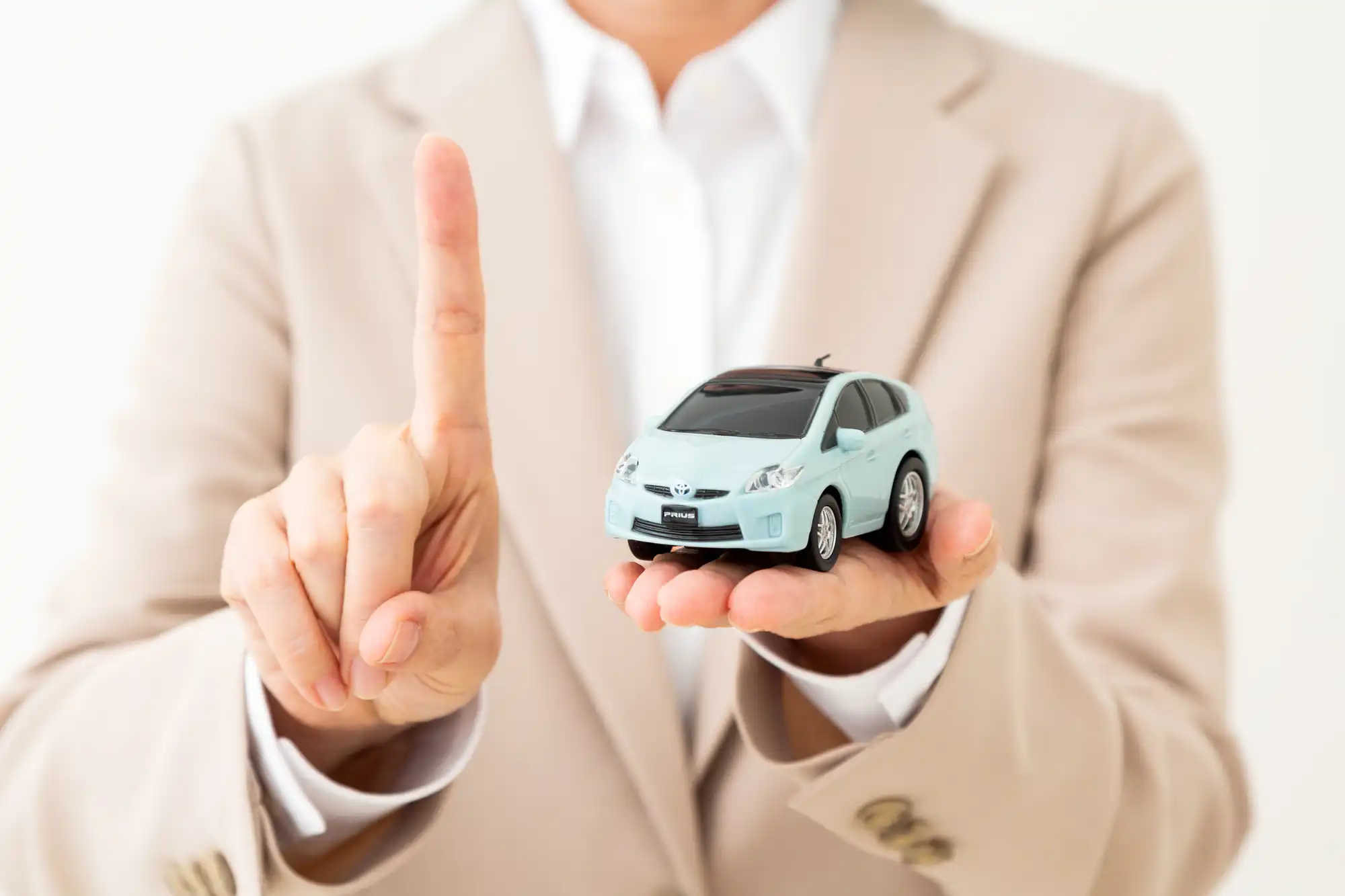 ミニカーを手に乗せて、逆の手で人差し指を立てている