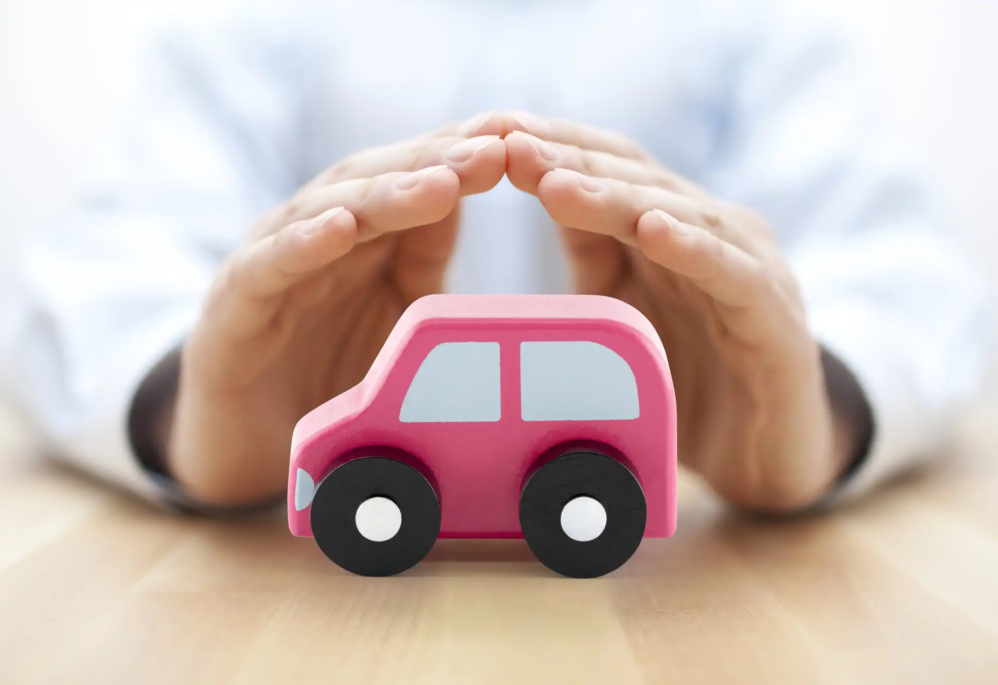 ピンクのミニカーを手で包みこんでいる