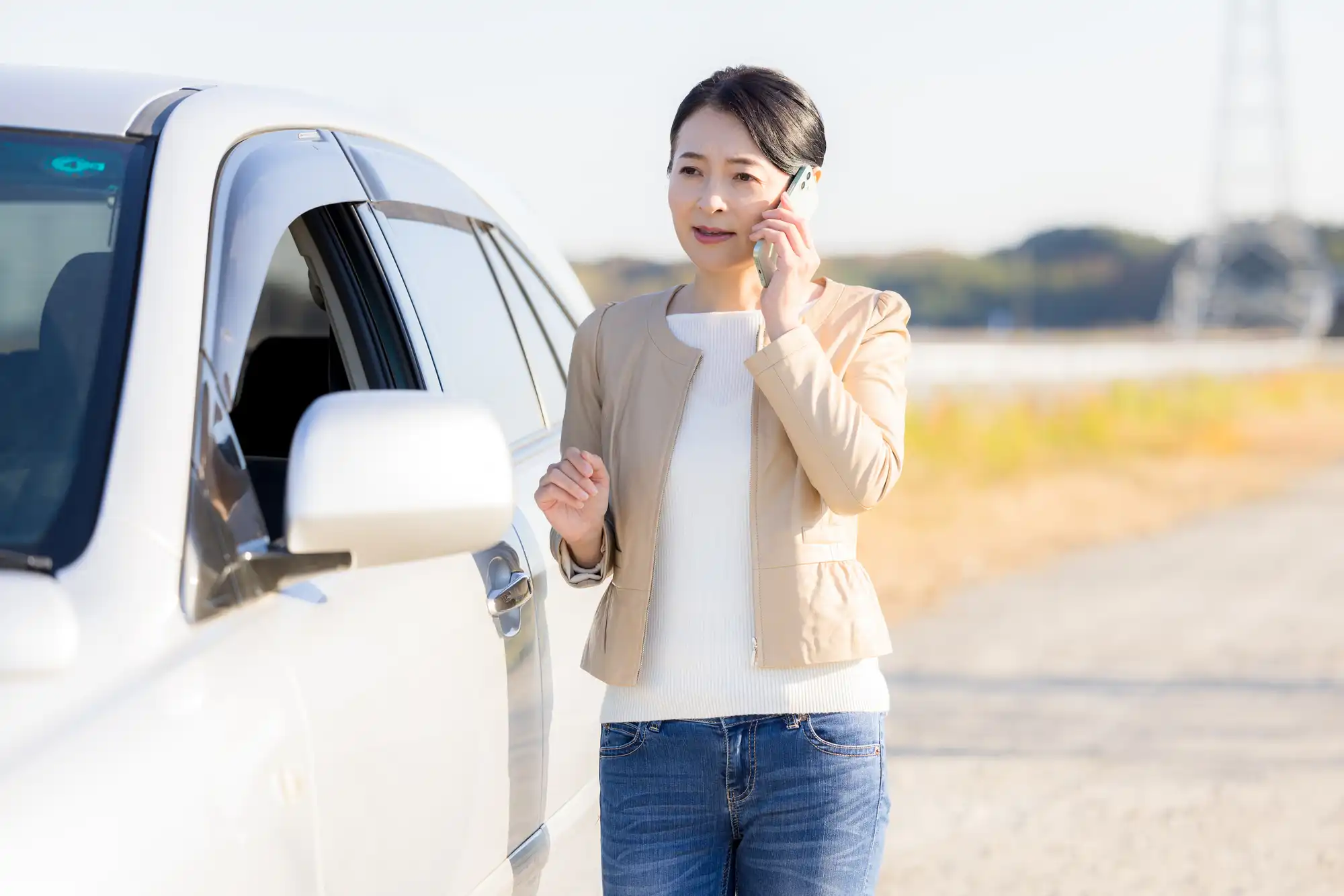 車から降りて電話する女性