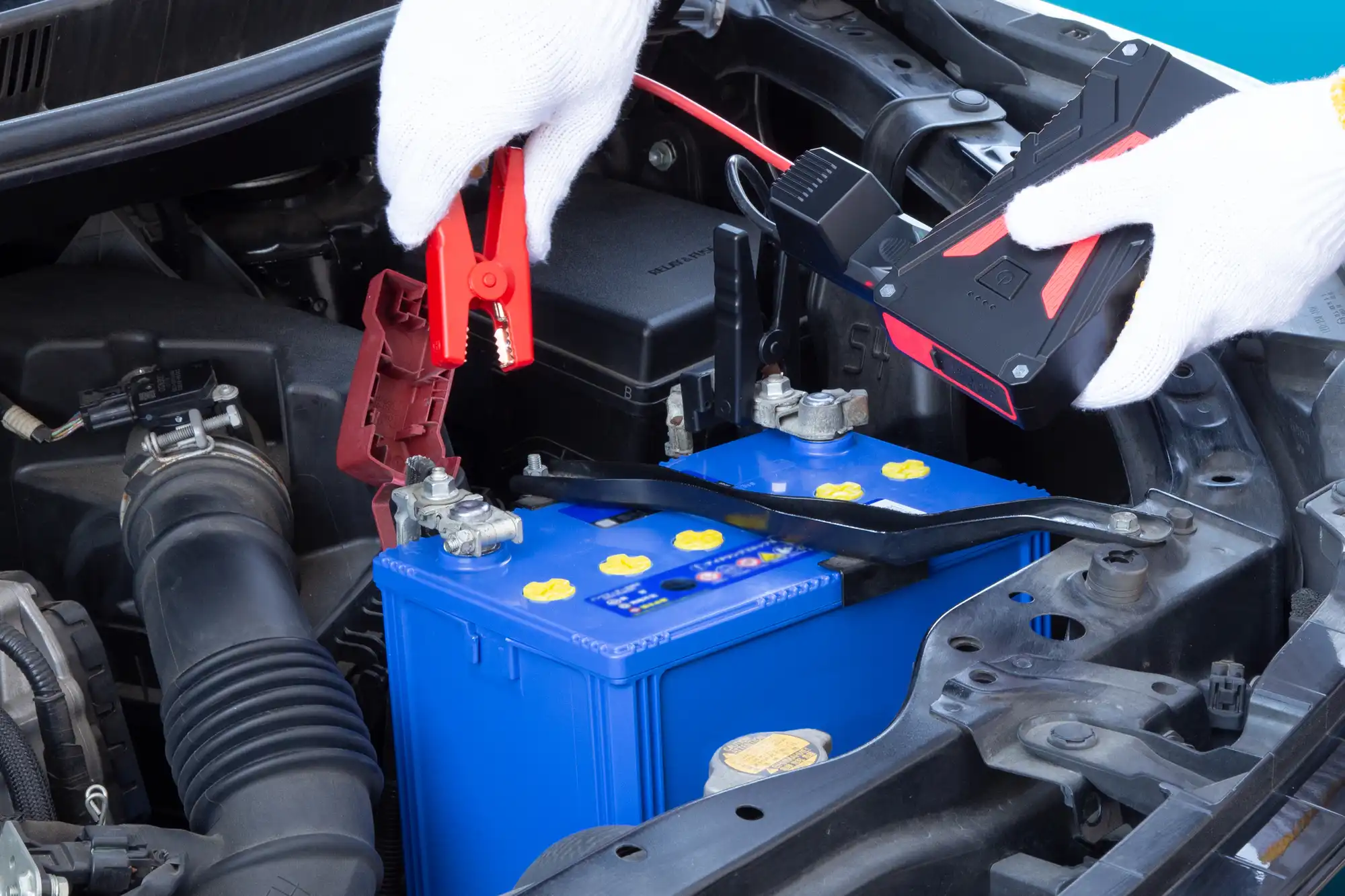 車のバッテリーにブースターケーブルを付けている